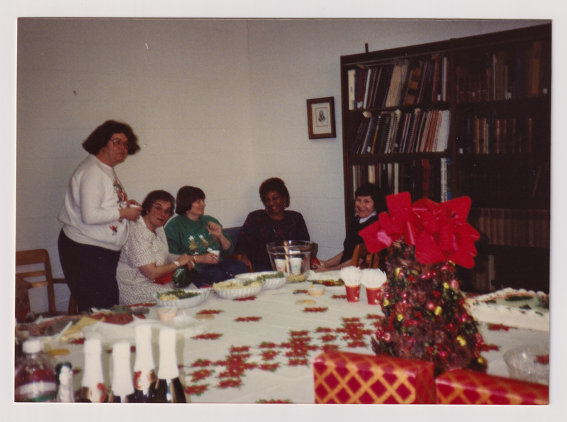 Five People Sitting Beyond the Refreshment Table