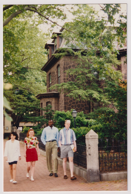 Admissions Building with 4 People Walking Near the Corner in Line
