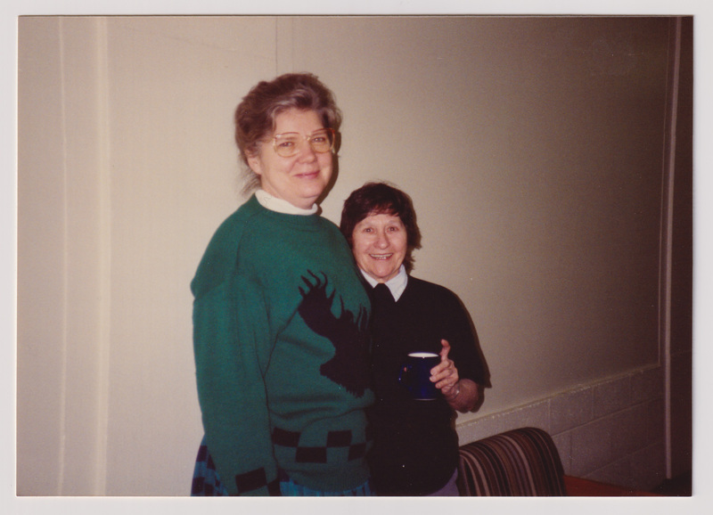 Two Women Smile and Stand Close Together
